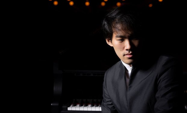 Bruce Liu vor einem Klavier sitzend