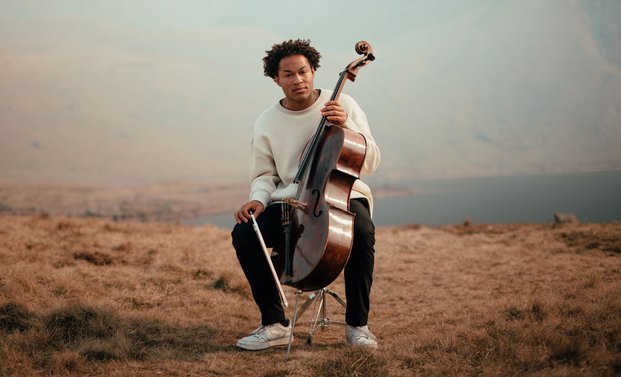 Sheku Kanneh-Mason sitting with his violoncello